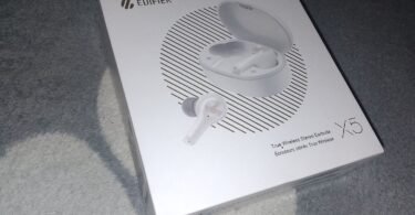 Person outdoors wearing wireless earbuds with adaptive noise control